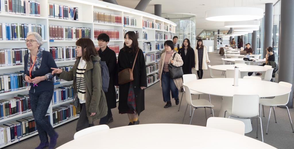Asian visitors guided by a librarian 