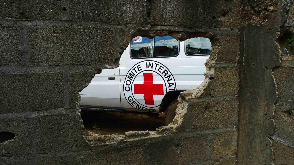 A hole in a wall showing an ICRC truck