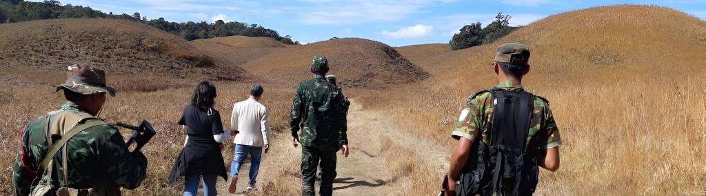 Image taken from the author's fieldwork, showing  from behind the author and a rebel group walking along a path. 