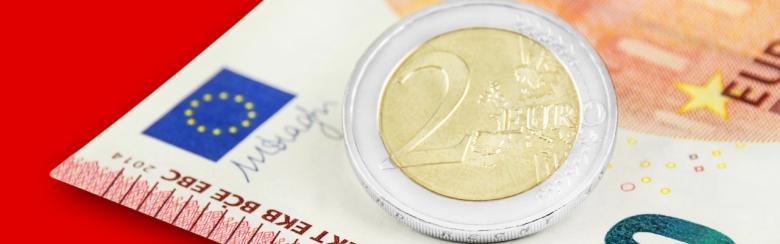 Photo of a 2-euro coin and a 10-euro note on a red background